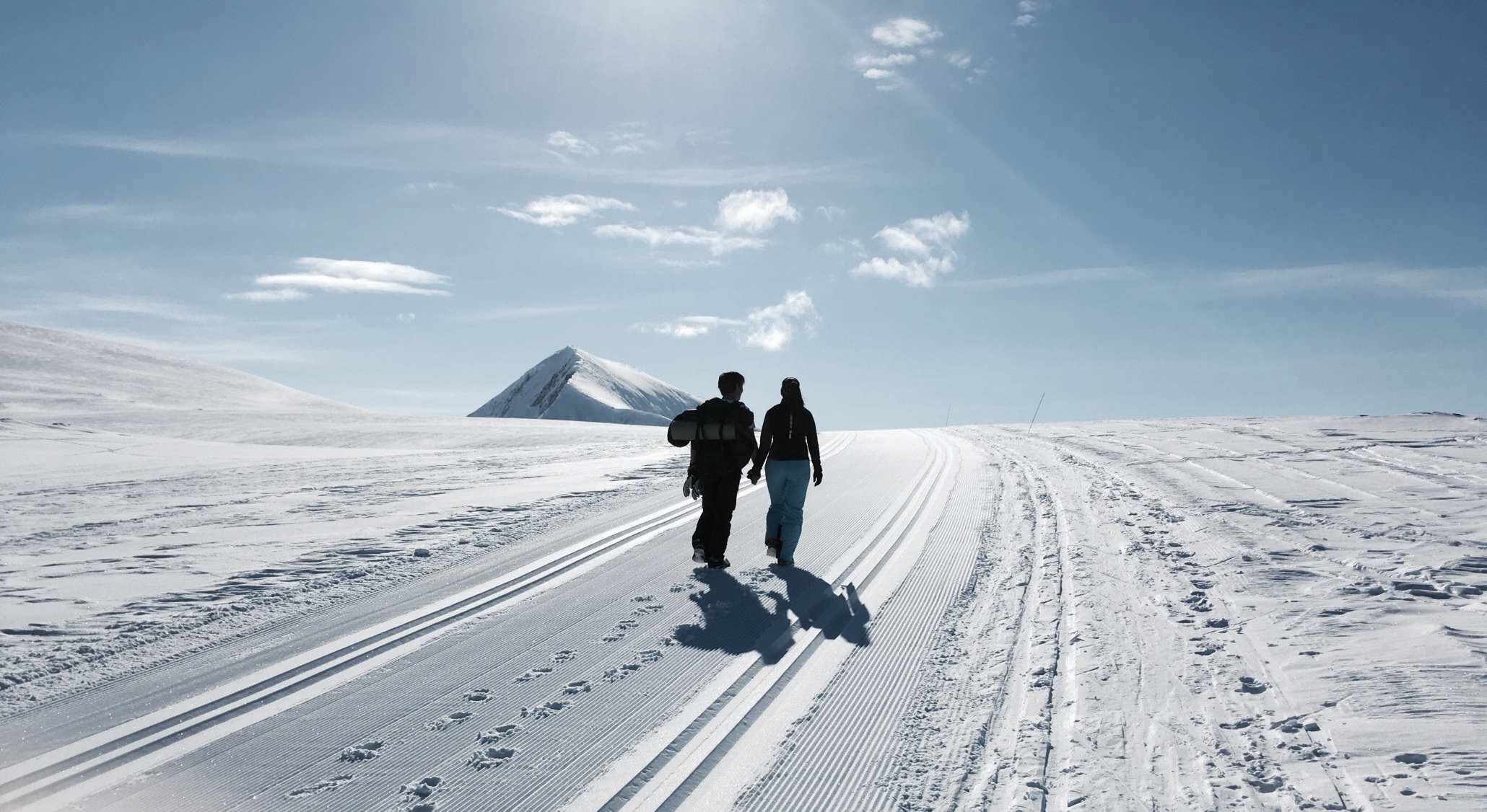 To personer på vei over et vinterfjell