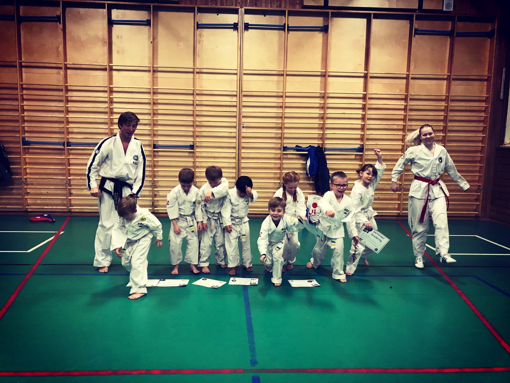 Barn og instruktører løper sammen etter en aktivitet i Taekwon-Do Kids